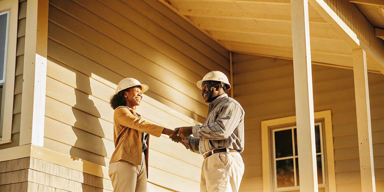 Texas homeowner reviewing paperwork with a roofing contractor outside a home