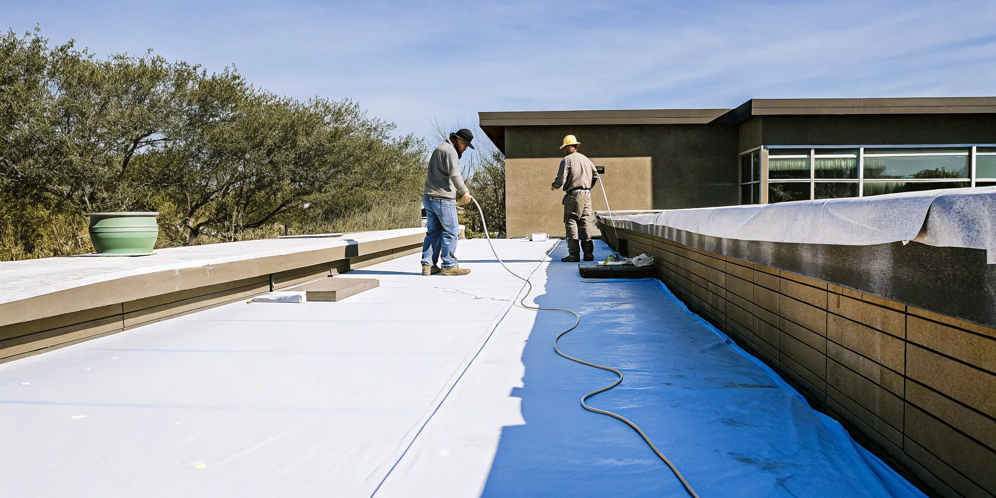Roofing crew heat-welding white TPO membrane seams on a commercial flat roof in Texas